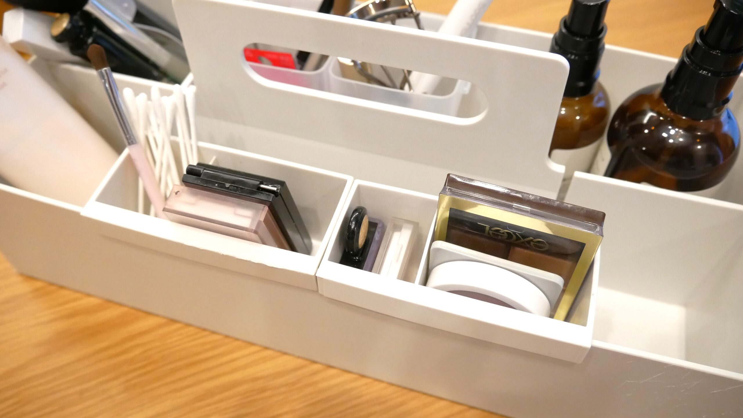 無印良品の仕切付ポケットを引っかけて、アイブロウやアイシャドウなどの小物を収納している様子