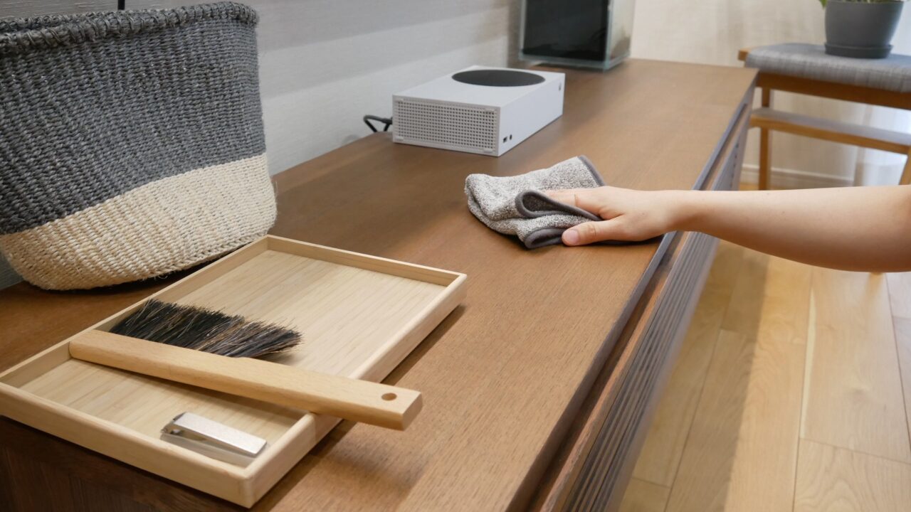 アッタラの油汚れクロスで、リビングのテレビ台をからぶきしている様子。
