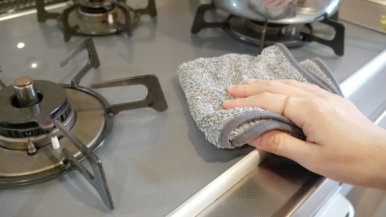 アッタラの油汚れクロスを、コンロまわりの油汚れ掃除に使っている様子。