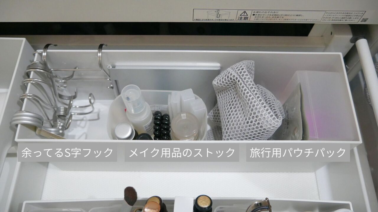 洗面台引き出し上段の奥。無印良品のファイルボックスにS字フックとメイク用品のストック、旅行用品を収納